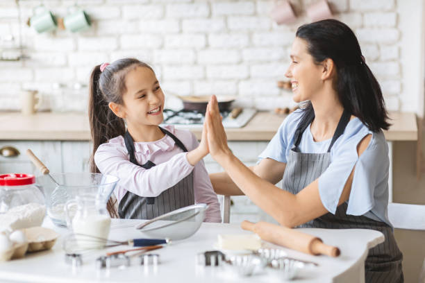 istock Mother and daughter giving high five to each in kitchen 1178524918