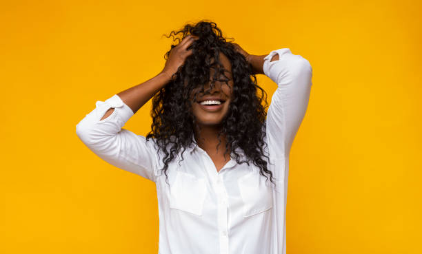 sexy black girl smiling with closed eyes, touching her hair - silence curly hair facial expression female imagens e fotografias de stock