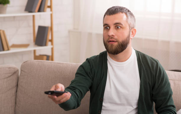 istock Surprised man watching tv at home at weekend 1178526985