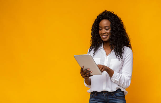 istock Interested african american girl using digital tablet on yellow background 1178527231