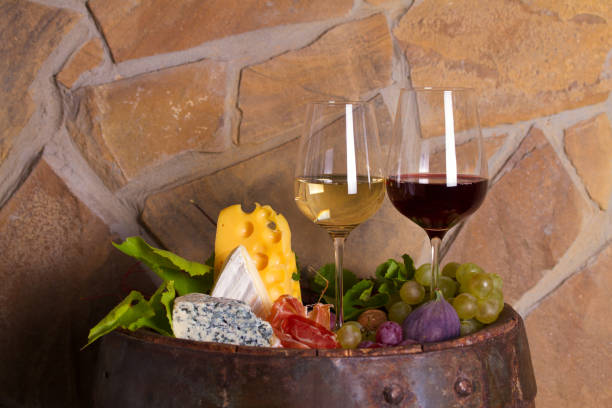 istock Red and white wine with  grapes, cheese, jamon, figs and nuts in wine cellar 1178528067