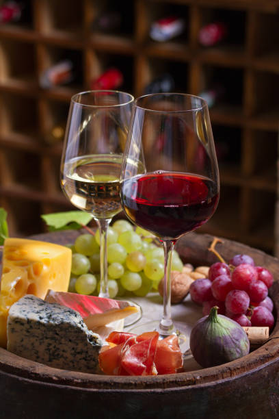 istock Red and white wine with  grapes, cheese, jamon, figs and nuts in wine cellar 1178528144