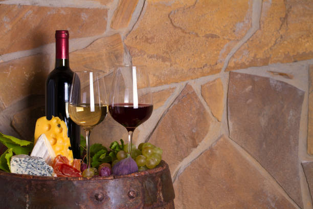 istock Red and white wine with  grapes, cheese, jamon, figs and nuts in wine cellar 1178528213