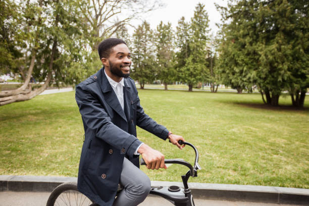 istock Excited afro businessman riding on bicycle to work, free space 1178528475