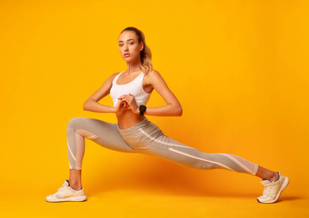istock Girl Doing Deep Lunge Exercise Over Yellow Background 1178528694
