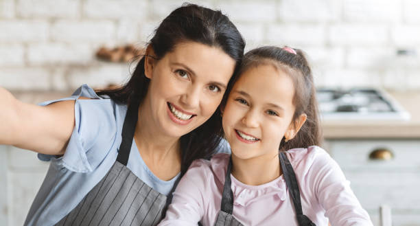 istock Beautiful mom and her cute daughter taking selfie in kitchen 1178528918