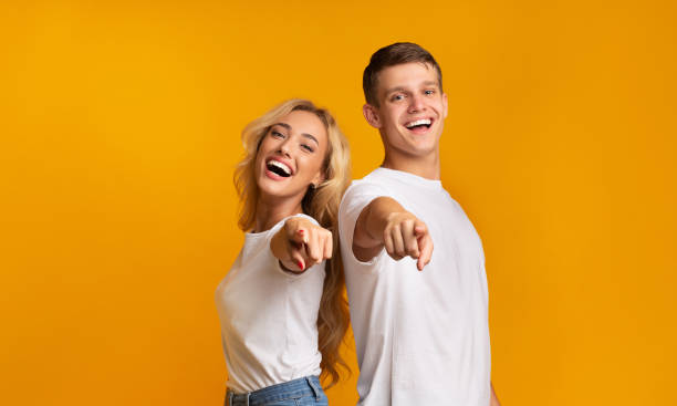 istock Cheerful couple laughing at something and pointing fingers to camera 1178529681