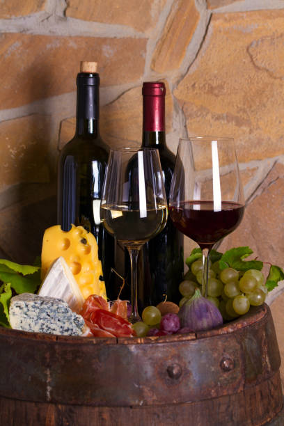 istock Red and white wine with  grapes, cheese, jamon, figs and nuts in wine cellar 1178529838