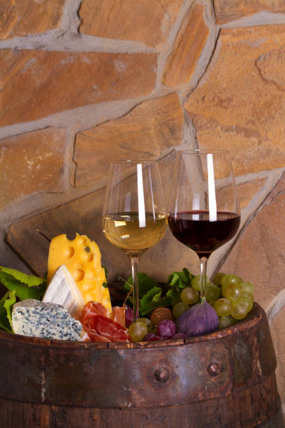 istock Red and white wine with  grapes, cheese, jamon, figs and nuts in wine cellar 1178529975