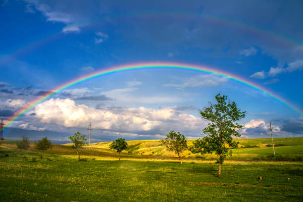istock Beautiful landscape with rainbow, green grass field and trees 1178530034