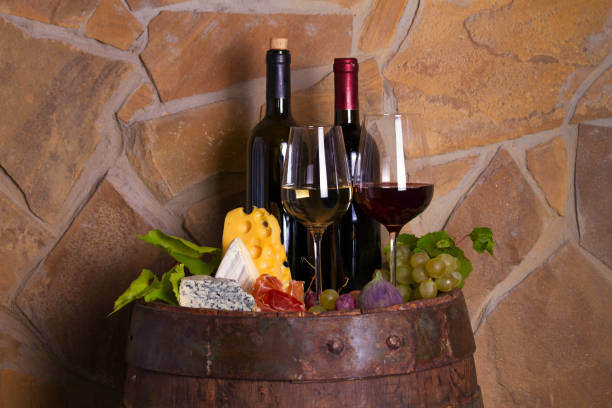 istock Red and white wine with  grapes, cheese, jamon, figs and nuts in wine cellar 1178531308