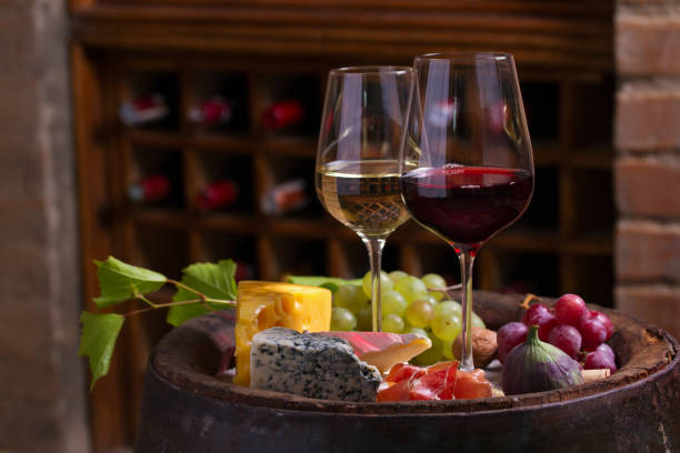 istock Red and white wine with  grapes, cheese, jamon, figs and nuts in wine cellar 1178531333