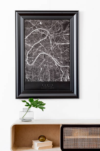 istock Modern scandinavian living room interior with black mock up poster map frame, design commode, tropical leaf, books and elegant accessories. Template. Stylish home decor. White wall. Minimalistic. 1178532042
