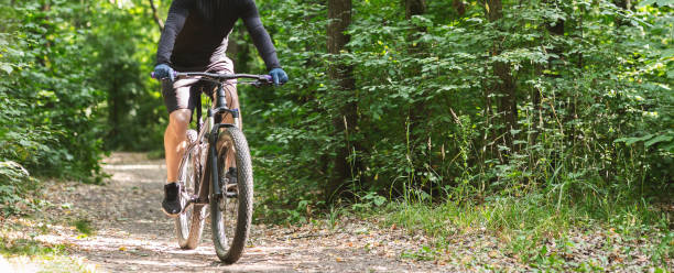 istock Young athletic cyclist riding down summer woods 1178532818