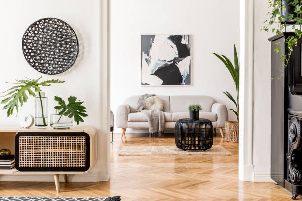istock Modern scandinavian interior design of open space with stylish wooden commode, gray sofa, black piano, rattan table, plant, tropical leaf and elegant personal accessories. Stylish home decor. Template 1178533049