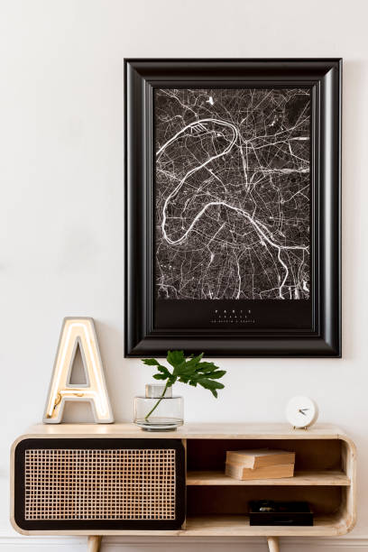 istock Modern scandinavian living room interior with black mock up poster map frame, design commode, tropical leaf, books, cement letter and elegant accessories. Template. Stylish home decor. Minimalistic. 1178533954