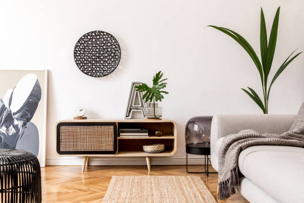 istock Stylish scandinavian living room interior with gray sofa, black lamp, design commode, tropical plants, sculpture, books and personal accessories. Mock up abstract paintings on the wall. Template. 1178534660