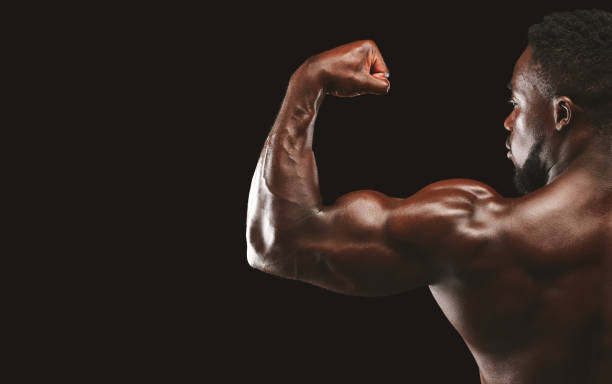 istock Strong biceps of afro athlete on black background 1178534968