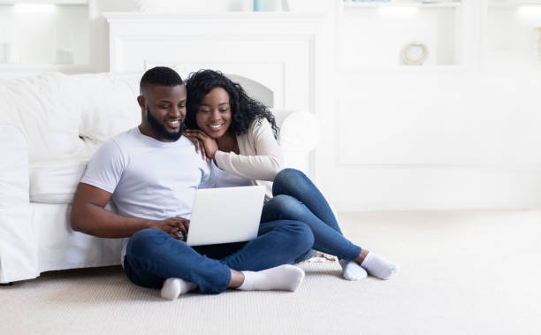 istock Young black couple using laptop at home planning summer vacation 1178535049