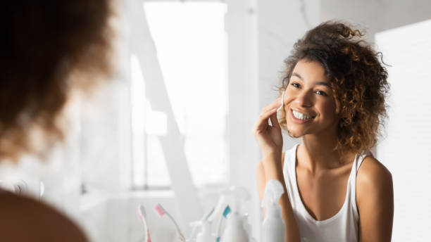 istock Afro Girl Cleaning Face Using Cotton Pads In Bathroom, Panorama 1178535854