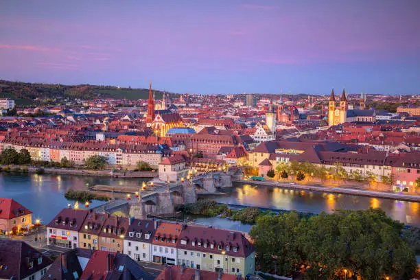Cityscape image of Wurzburg with Old Main Bridge over Main river during beautiful autumn sunset.