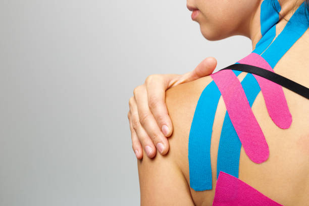 kinesiotaping, kinesiology. female athlete with kinesiotape, muscle tape on shoulder - kinesio imagens e fotografias de stock