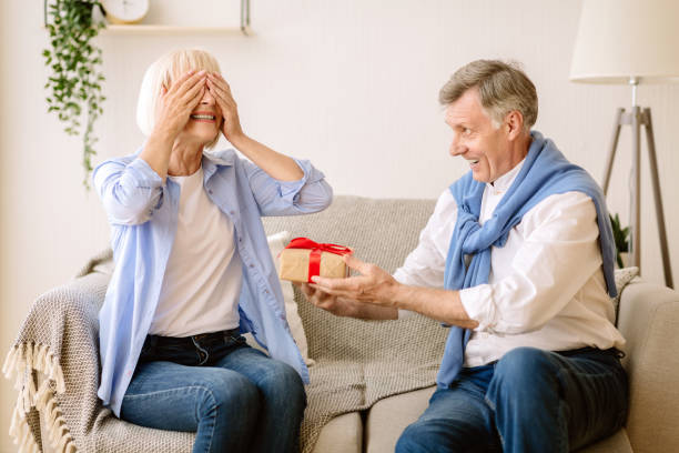 istock Surprise. Senior man giving present to wife 1178536520