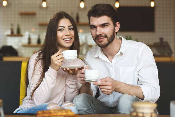 istock Happy caucasian couple sitting in cafe and drinking coffee 1178536709