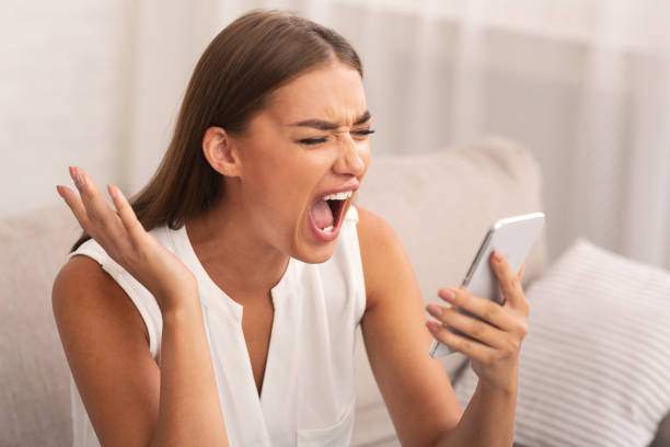 istock Angry Woman Shouting On Cellphone Sitting On Sofa At Home 1178537437
