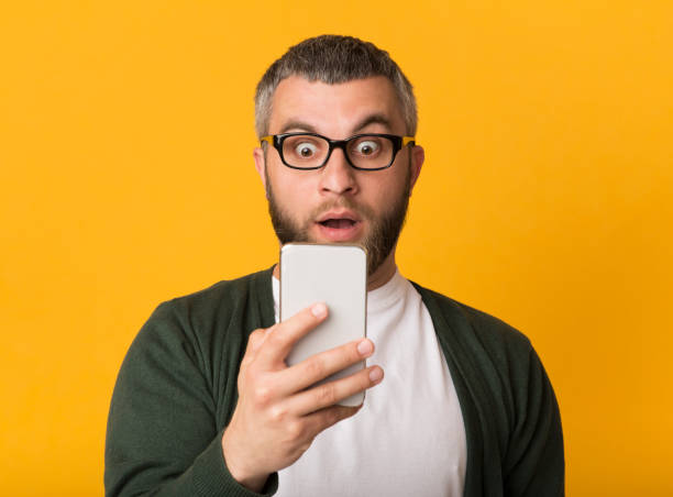 istock Surprised handsome man looking at cellphone with eyes wide open 1178542204