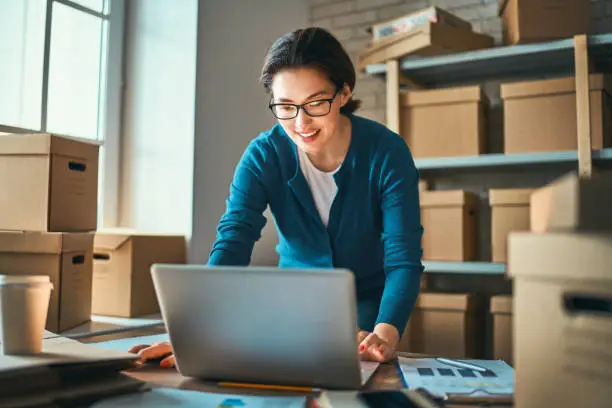 Photo of Woman is working at warehouse for online store.