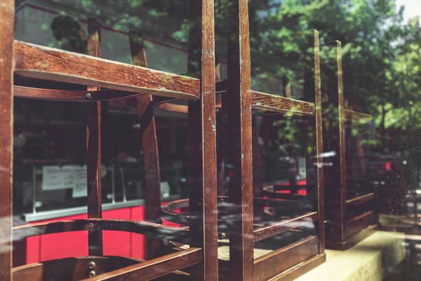 old chairs of an restaurant stacked behind a window