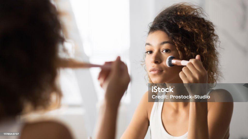 Afro vrouw gezicht poeder met make-up borstel in de badkamer - Royalty-free Make-up Stockfoto