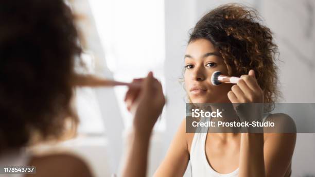 Afro Vrouw Gezicht Poeder Met Makeup Borstel In De Badkamer Stockfoto en meer beelden van Make-up