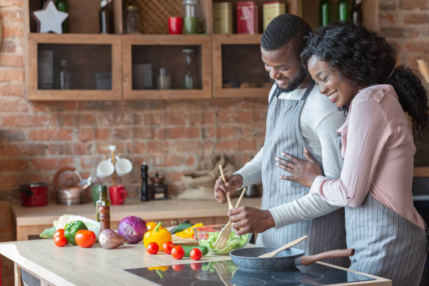 istock Cheerful black family cooking dinner together in kitchen 1178543812