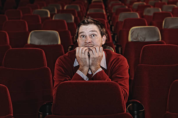 istock Scared Man Sitting in Movie Theatre Alone 117854473