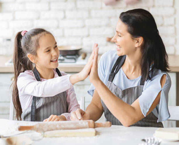 istock Cute girl and her mom giving high five in kitchen 1178544828