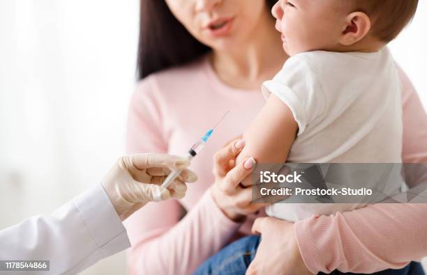 Doctor Giving Intramuscular Injection To Little Baby Stock Photo - Download Image Now