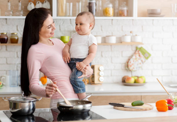 istock Mother cooking lunch with baby at kitchen 1178545215