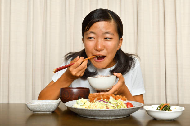 istock Japanese girl enjoys having dinner 1178545317