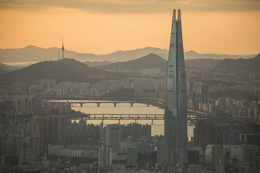 Seoul sunset, golden sky over downtown skyscraper cityscape, panoramic view