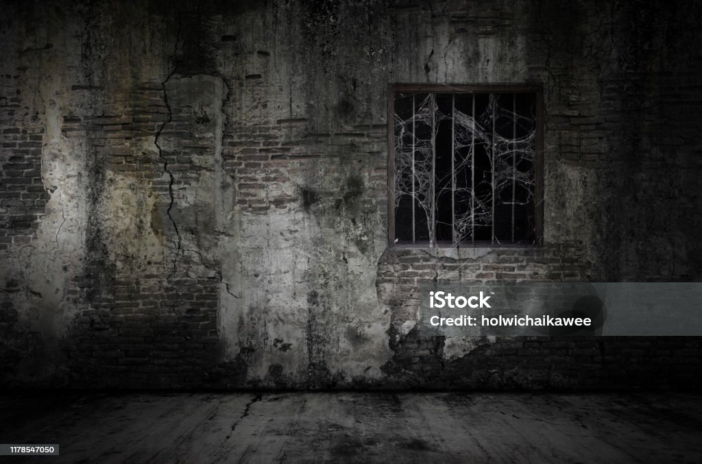Window and rusty bars covered with cob web or spider web on prison old bricks wall and dusty floor Window and rusty bars covered with cob web or spider web on prison old bricks wall and dusty floor, concept of horror and Halloween Halloween Stock Photo