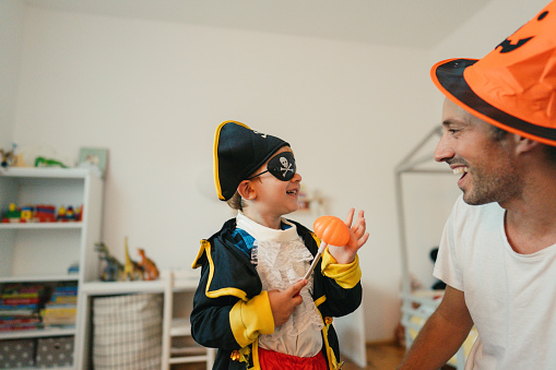 Photo of costumed boy and his dad, playing make believe at home