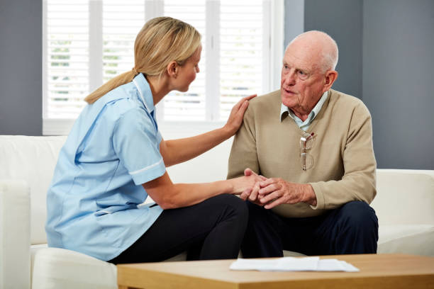 istock Healthcare worker comforting elderly man at home 1178548320