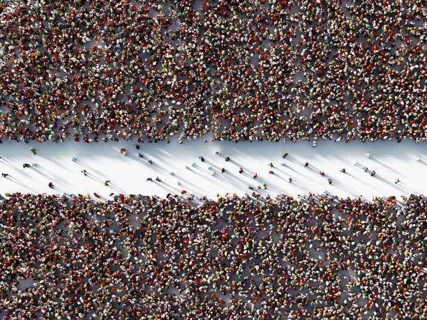 multidão humana que dá forma a duas zonas separadas no fundo branco - dividing - fotografias e filmes do acervo