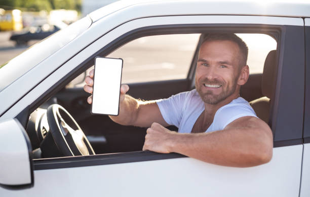 istock An attractive man in a car shows a smartphone. 1178550138