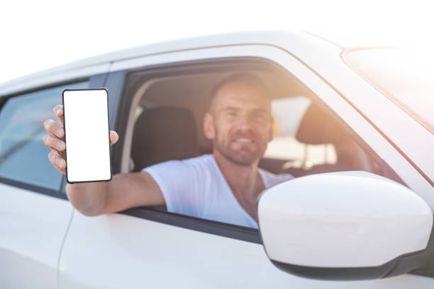 istock An attractive man in a car shows a smartphone. 1178550142