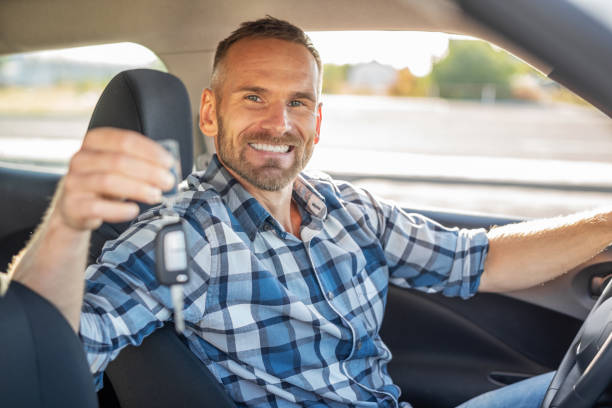 istock A man in a car shows a key. 1178550235