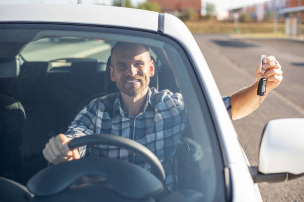 istock A man in a white car shows a key. 1178550249