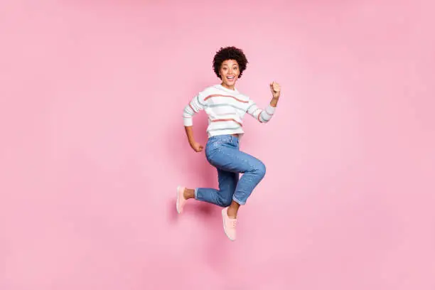 Photo of Full length body size photo of excited cute crazy cheerful girlfriend running towards shopping mall discounted wearing jeans denim striped white sweater isolated over pastel color background